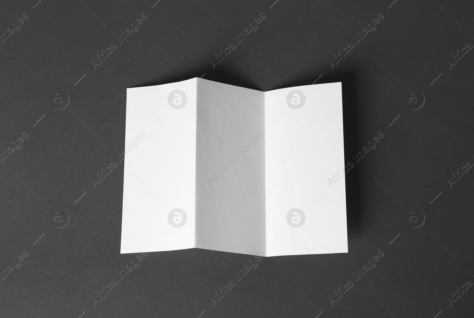 Photo of Blank brochure on dark grey background, top view. Mock up for design