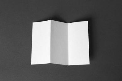 Photo of Blank brochure on dark grey background, top view. Mock up for design