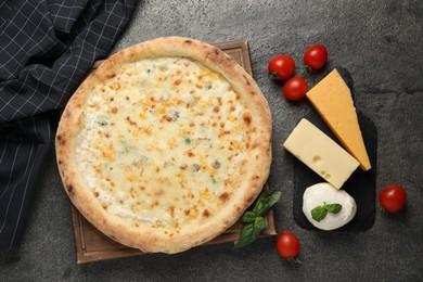 Photo of Delicious cheese pizza and ingredients on dark grey table, flat lay