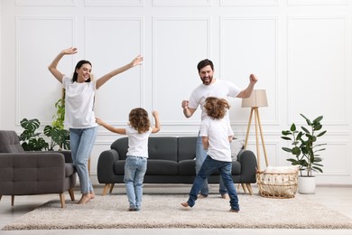 Photo of Happy family dancing and having fun in living room