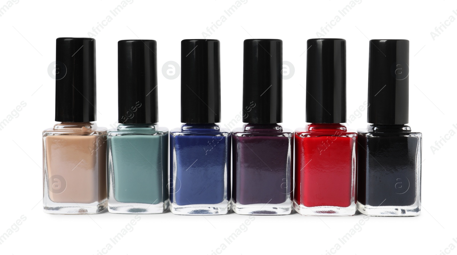 Photo of Beautiful nail polishes in bottles isolated on white