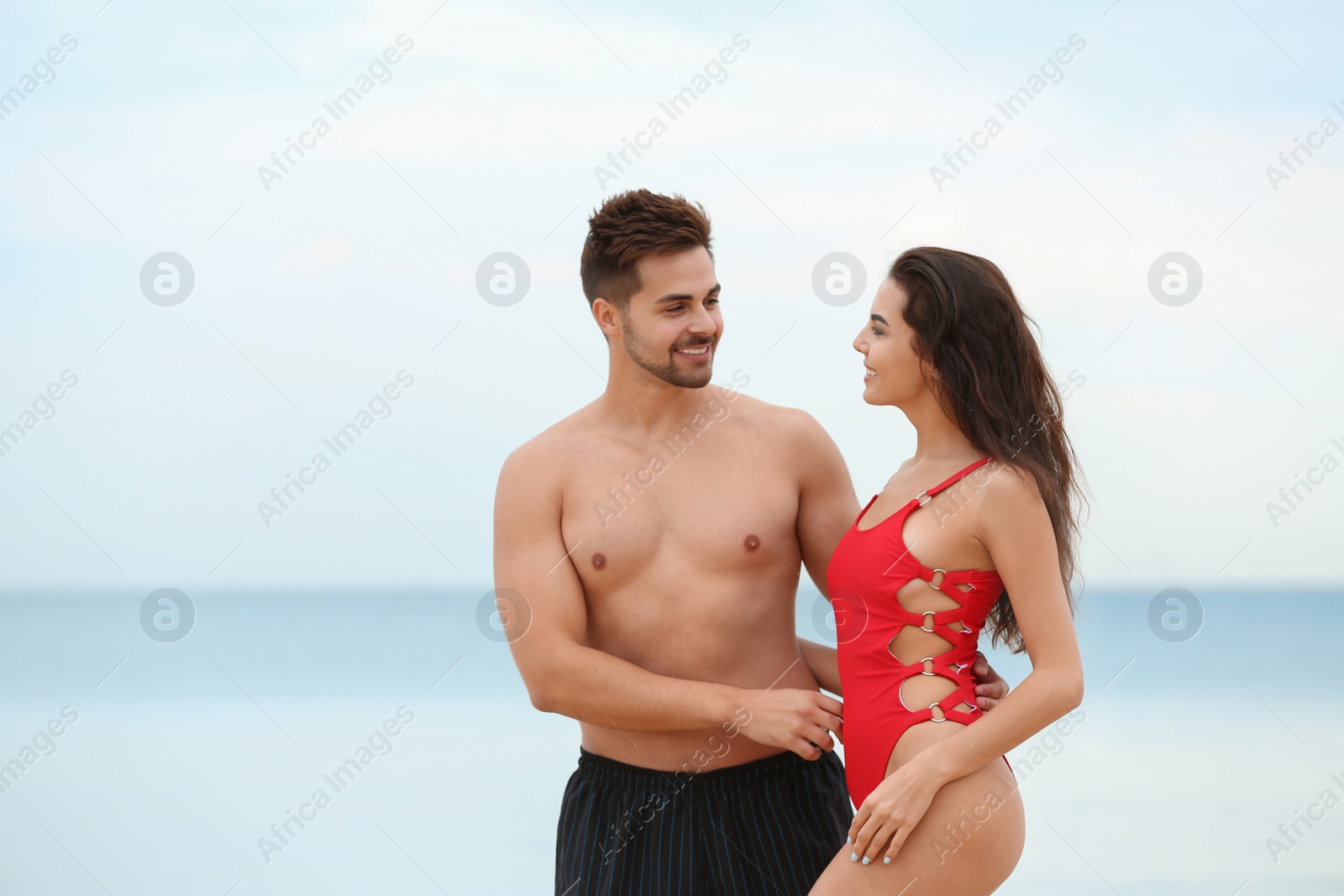 Photo of Happy young couple spending time together on beach