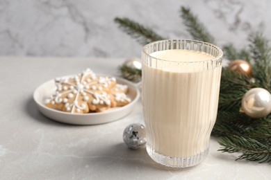 Photo of Glass of delicious eggnog on light table, space for text