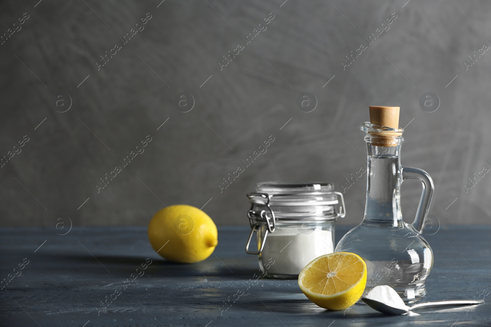 Photo of Composition with vinegar, lemon and baking soda on table. Space for text