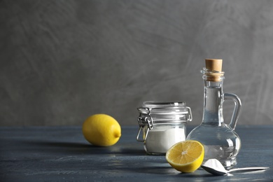Photo of Composition with vinegar, lemon and baking soda on table. Space for text