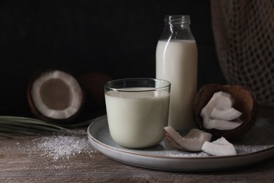 Composition with coconut milk on wooden table, space for text