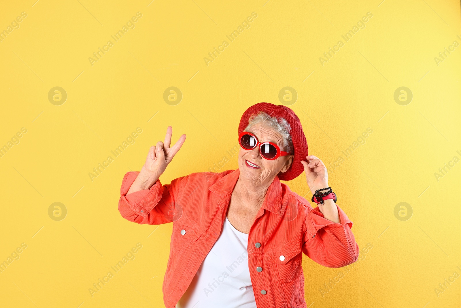 Photo of Portrait of cool grandmother on color background