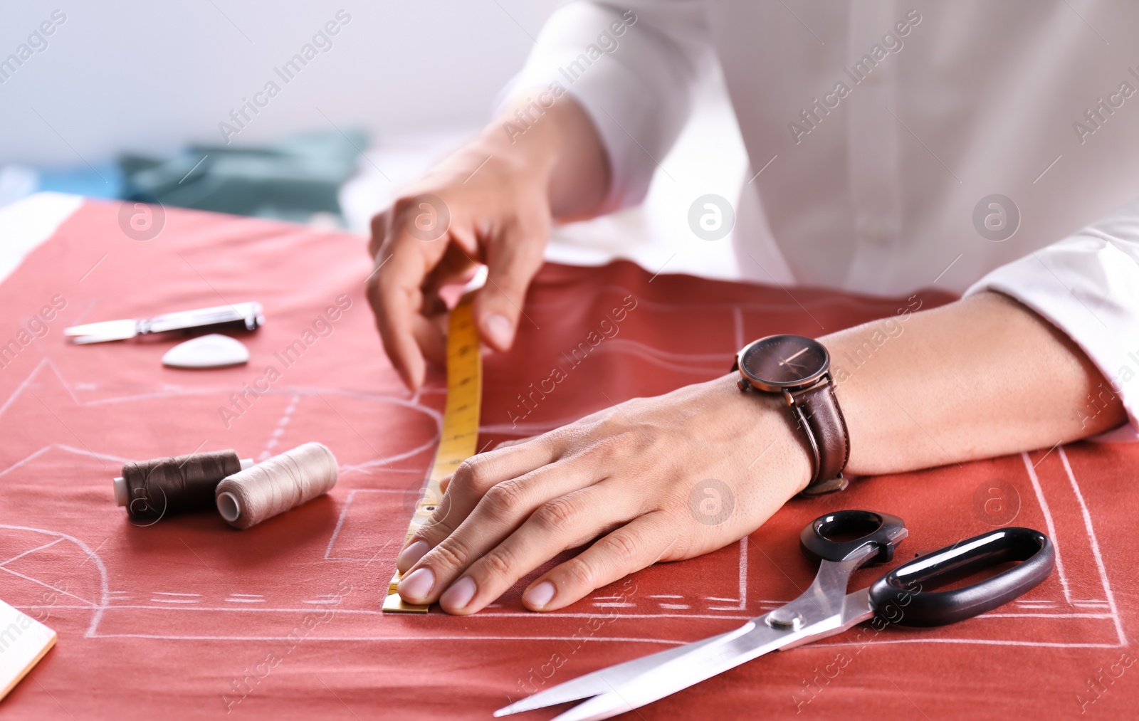 Photo of Tailor working at table in atelier, closeup