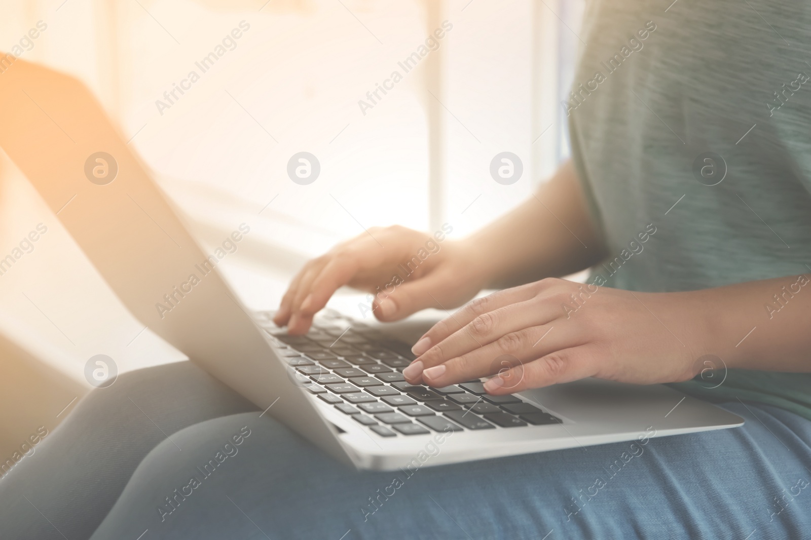 Image of Woman working with laptop near window indoors, closeup