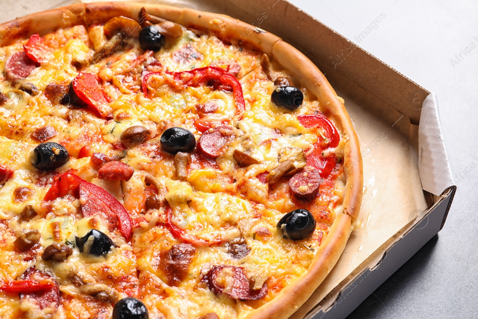 Photo of Cardboard box with delicious pizza, closeup