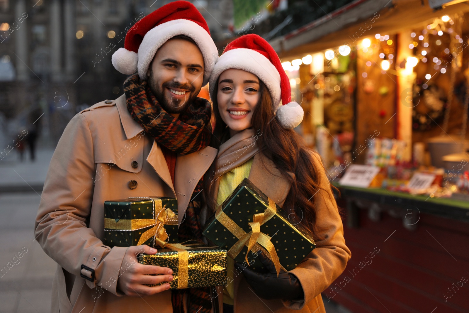 Photo of Lovely couple with Christmas presents at winter fair