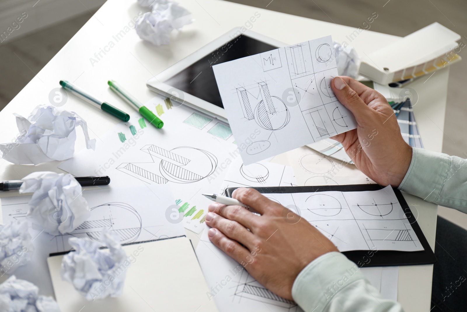 Photo of Male designer working at white table, closeup