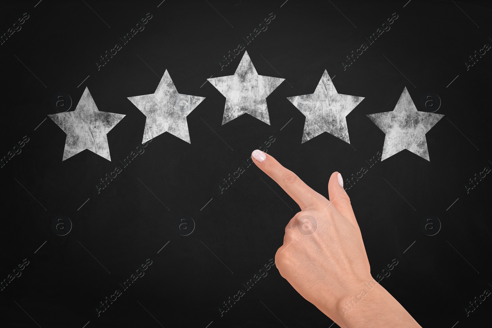 Image of Quality rating. Woman pointing at chalked stars on blackboard, closeup