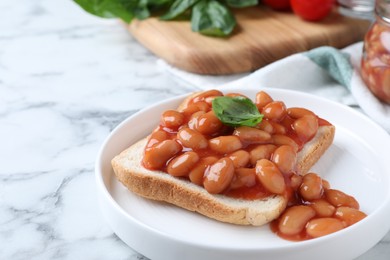 Photo of Toast with delicious canned beans on white marble table