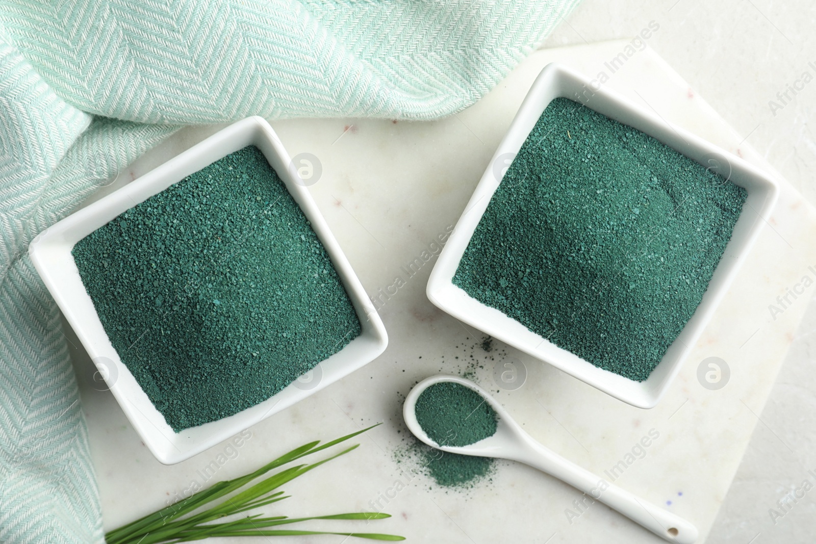 Photo of Flat lay composition with bowls of spirulina powder on light table