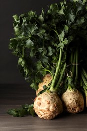 Photo of Fresh raw celery roots on wooden table