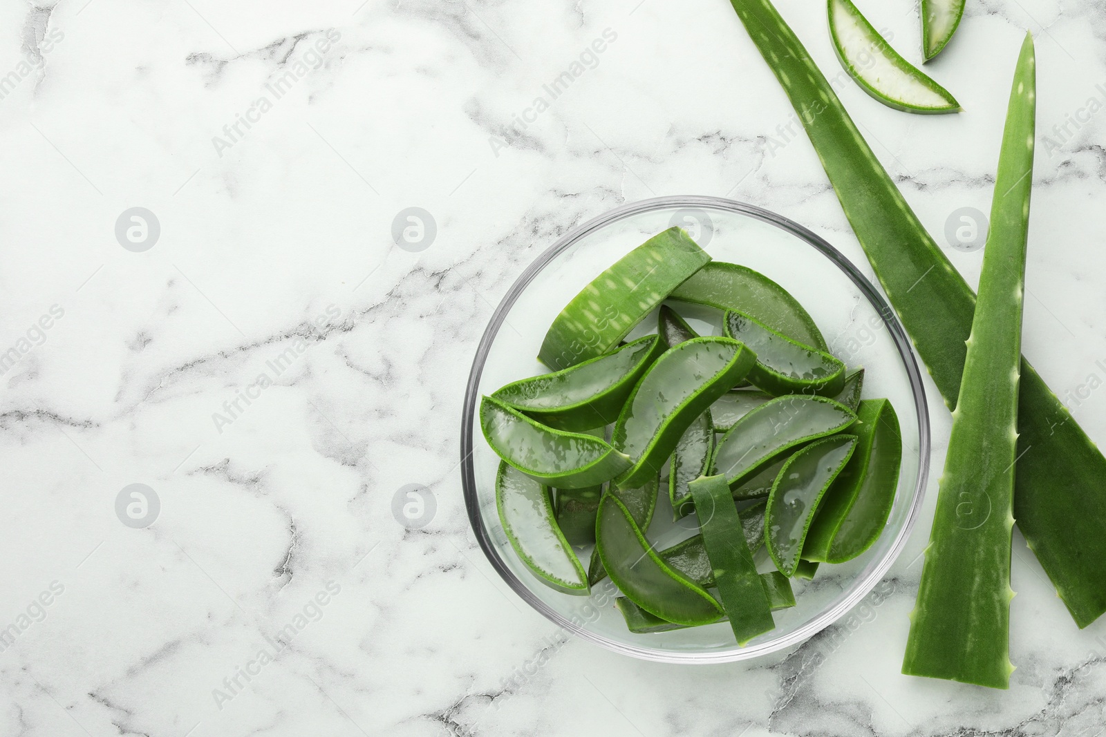 Photo of Fresh aloe vera pieces on white marble table, flat lay. Space for text