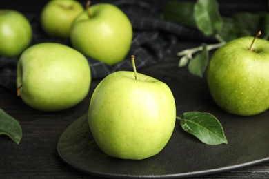 Fresh ripe green apples on black wooden table