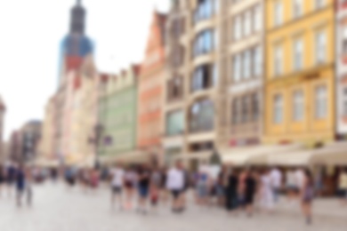 Photo of Blurred view of crowded city street on sunny day