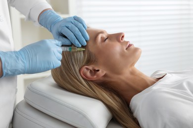 Trichologist giving injection to patient in clinic, closeup