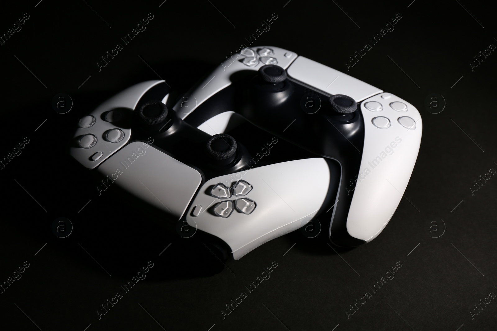 Photo of Two wireless game controllers on black background