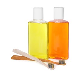 Bottles of mouthwash and toothbrushes isolated on white