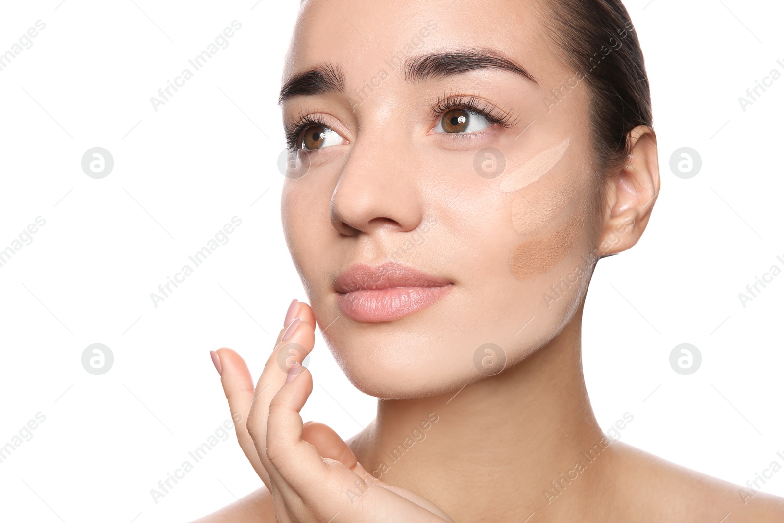 Photo of Young woman with different shades of skin foundation on her face against white background