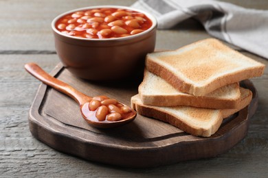 Toasts and delicious canned beans on wooden table