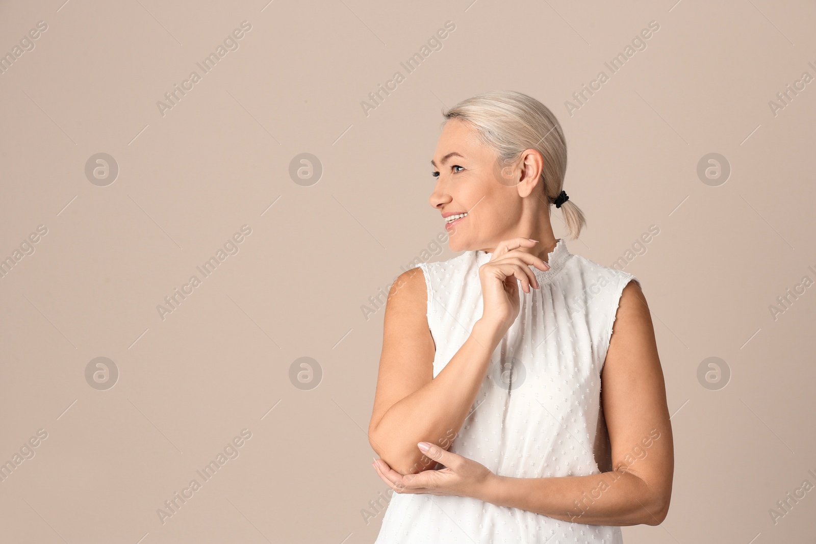 Photo of Portrait of beautiful mature woman on beige background. Space for text