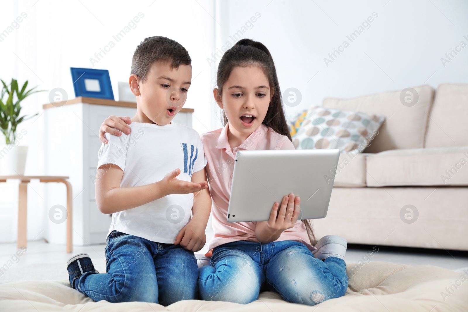 Photo of Little children using video chat on tablet at home