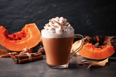 Photo of Delicious pumpkin latte on grey table, closeup