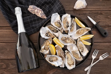 Photo of Fresh oysters with cut juicy lemon served on table, flat lay