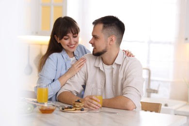 Photo of Happy couple spending time together during breakfast at home