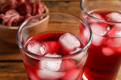Photo of Glasses of delicious iced hibiscus tea on table, closeup