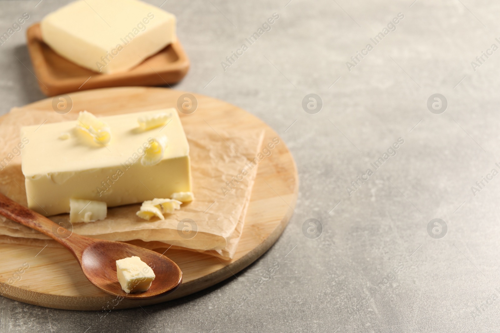 Photo of Block of tasty butter on grey table. Space for text