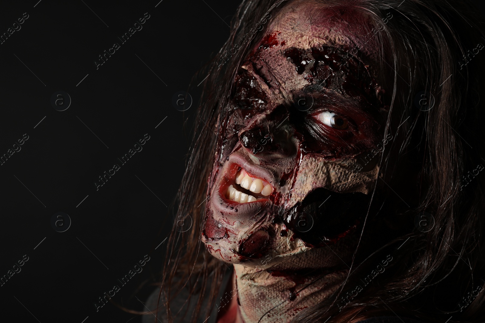 Photo of Scary zombie on dark background, closeup. Halloween monster