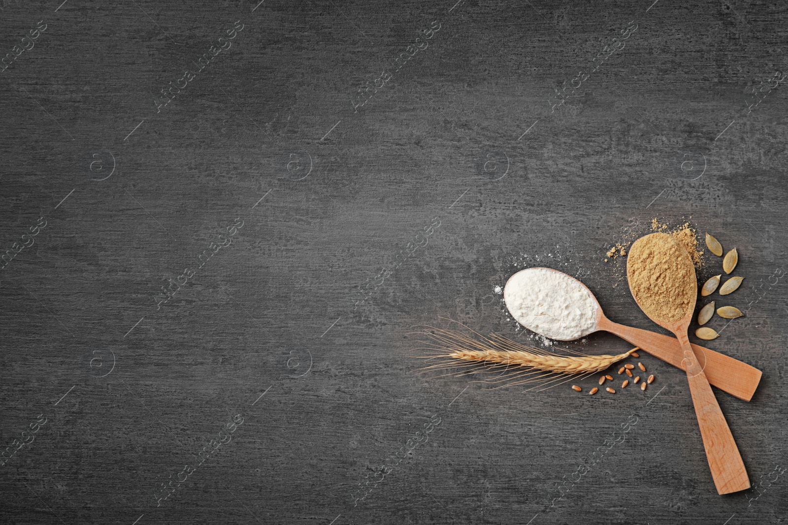 Photo of Spoons with different types of flour on gray background