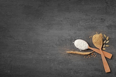 Photo of Spoons with different types of flour on gray background