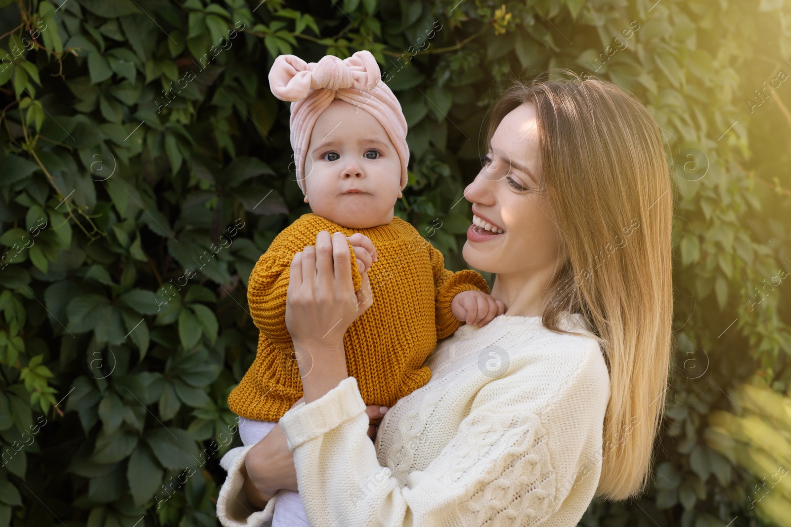 Photo of Happy mother with her little baby outdoors on sunny day