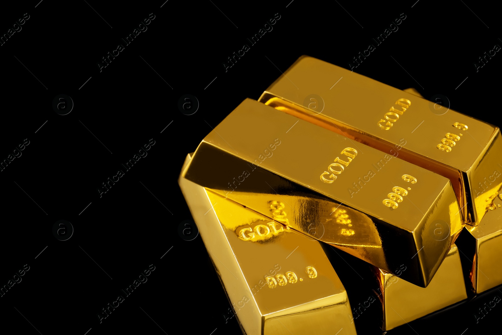 Photo of Stack of shiny gold bars on black background. Space for text