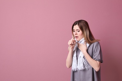 Woman coughing on color background