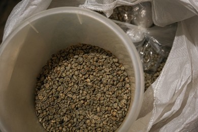 Raw coffee beans in sack, above view