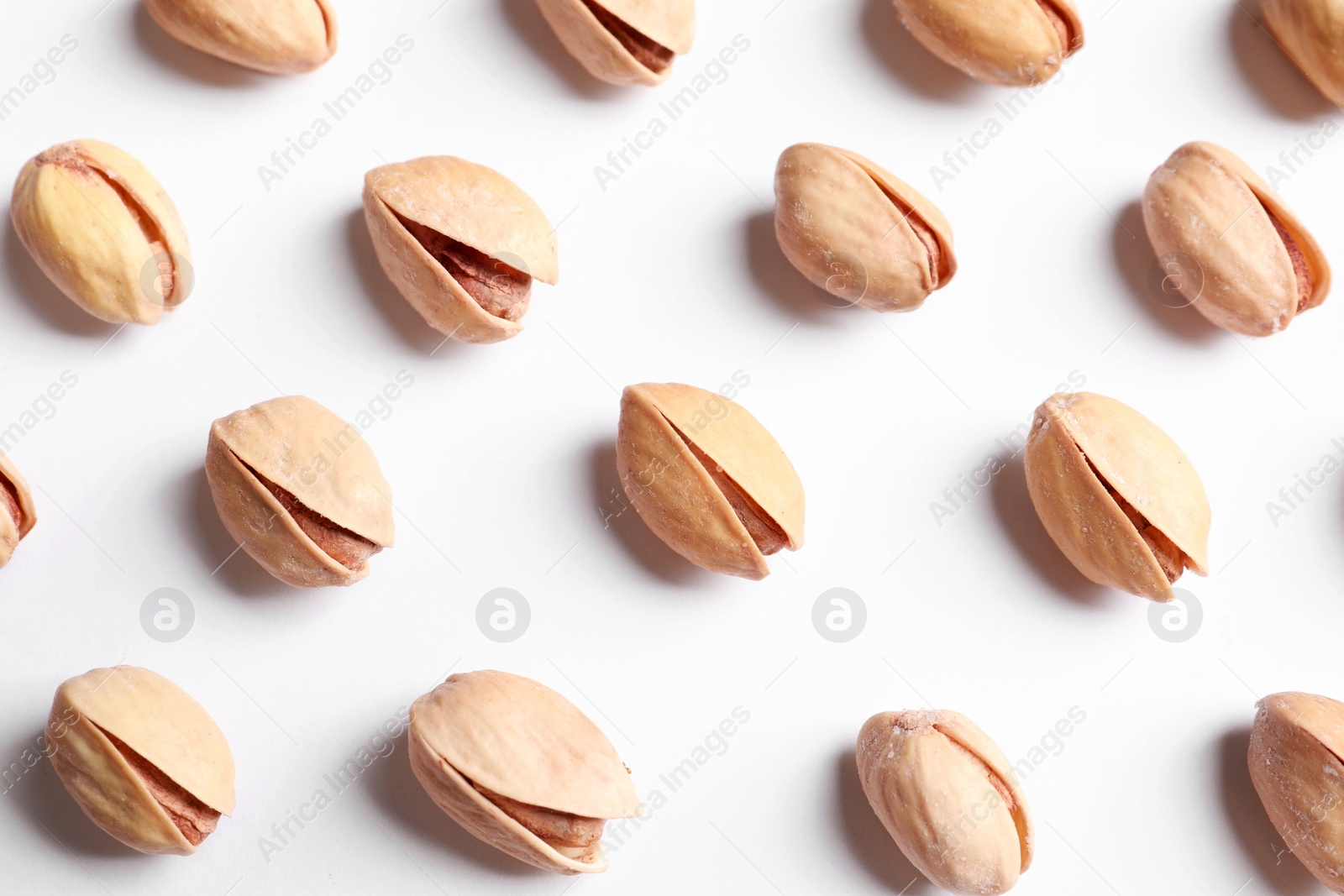 Photo of Organic pistachio nuts on white background, flat lay