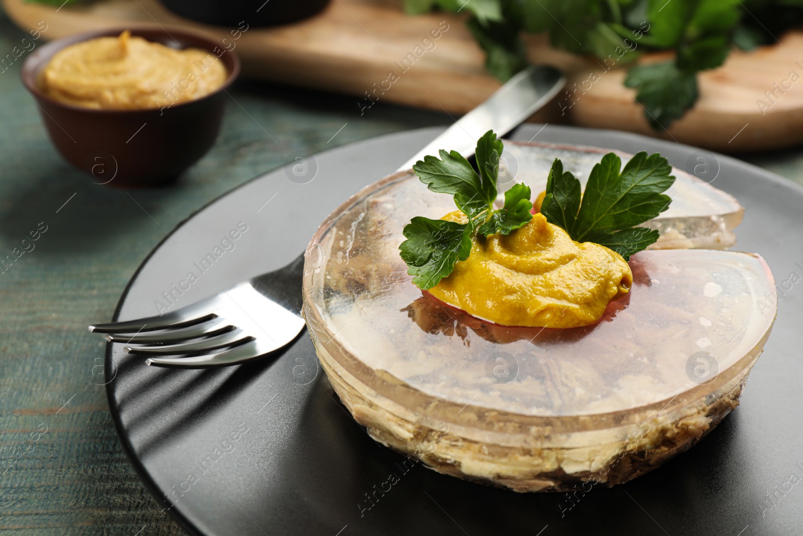 Photo of Plate with delicious aspic on light blue wooden table, closeup