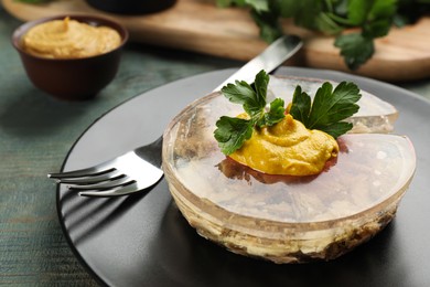 Photo of Plate with delicious aspic on light blue wooden table, closeup