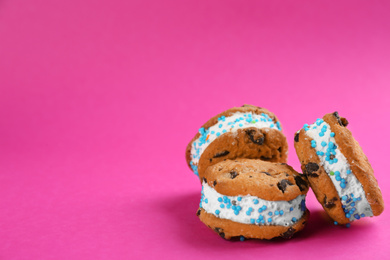 Photo of Sweet delicious ice cream cookie sandwiches on pink background. Space for text