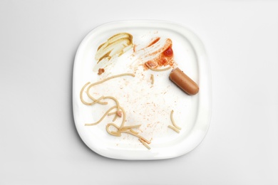 Photo of Dirty plate with food leftovers on white background, top view