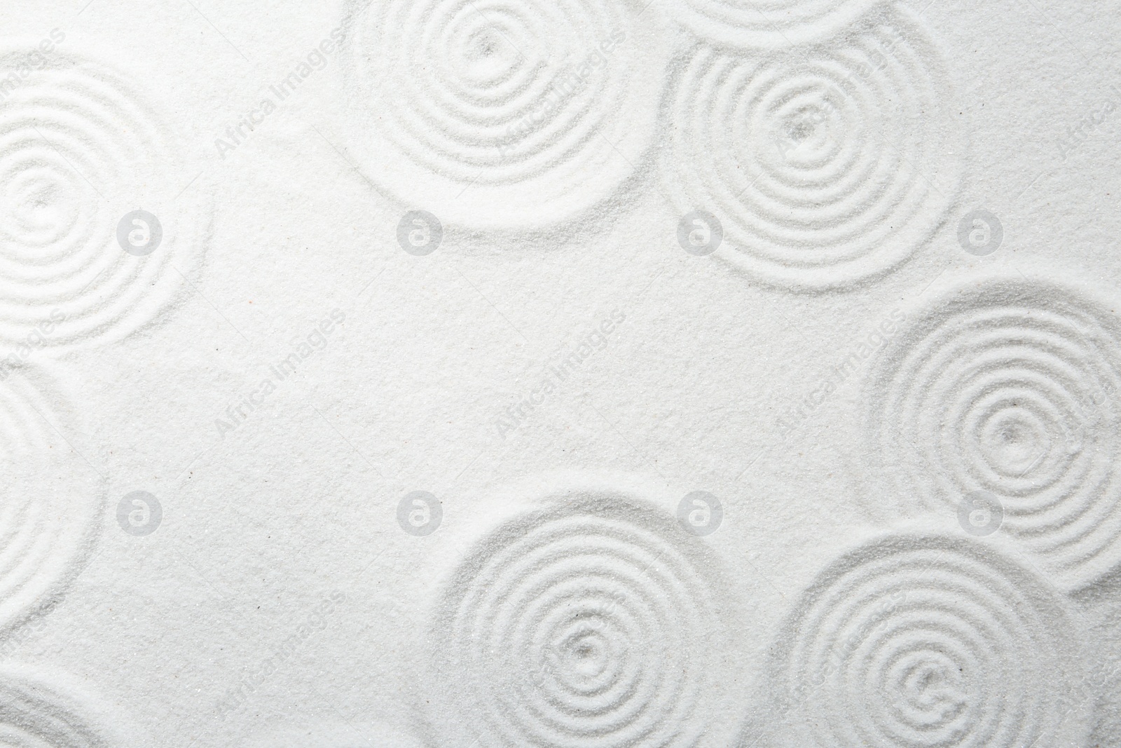 Photo of Zen rock garden. Circle patterns on white sand, top view