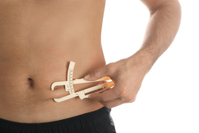 Photo of Man measuring body fat layer with caliper on white background, closeup. Nutritionist's tool