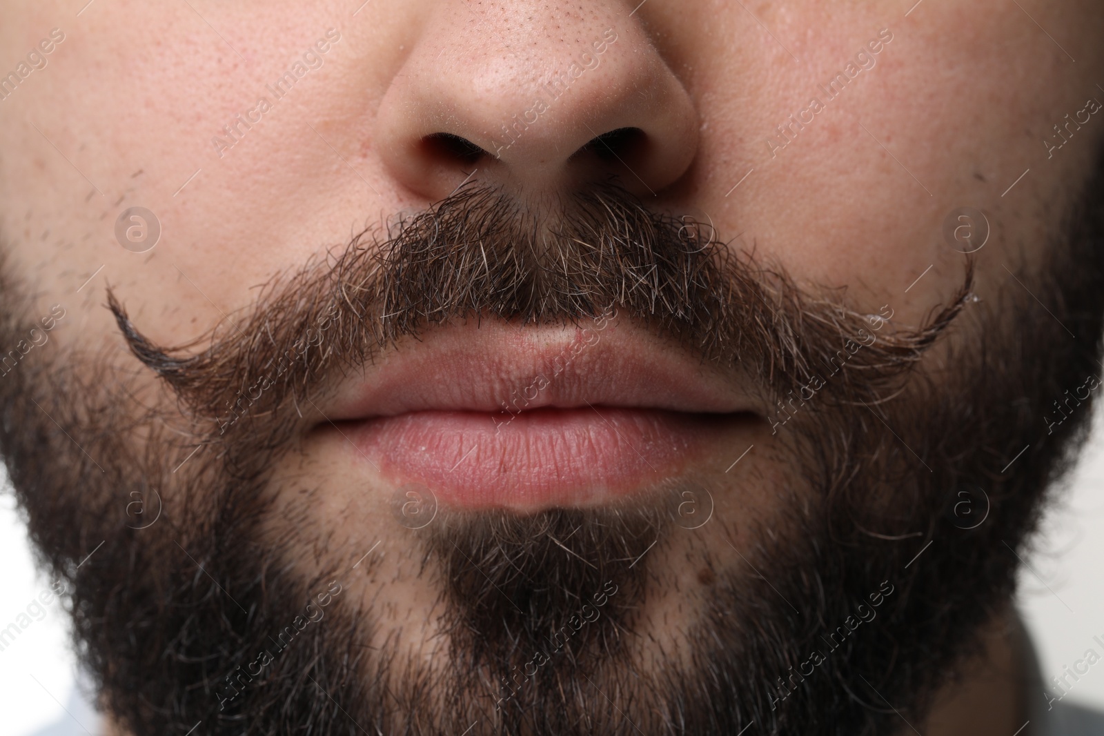 Photo of Young man with mustache on white background, closeup